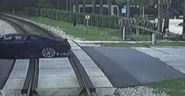 Woman narrowly escapes car as train approaches (Video)