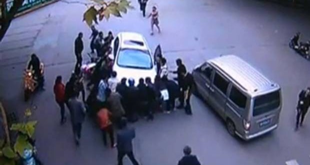 Car Lifted, Woman Saved In China : Watch how this woman escapes unhurt despite getting run over by a car
